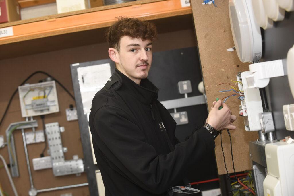 A photograph of Ethan working on electrics