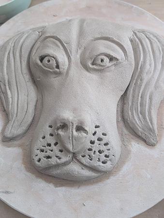 A dog's head sculpted in clay
