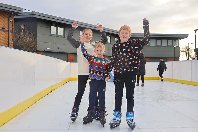 Three people on an ice rink