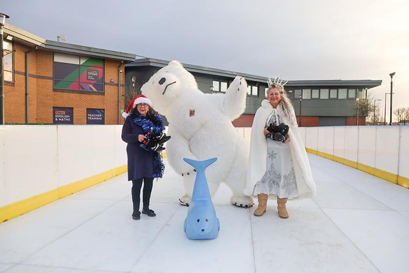Two people and a polar bear on the ice rink