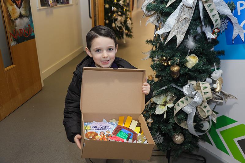 Boy holding a box with Narnia themed items