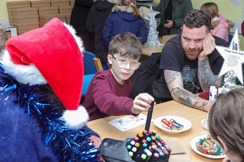 A boy doing some crafts with an adult