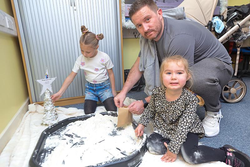 Two children and an adult doing crafts